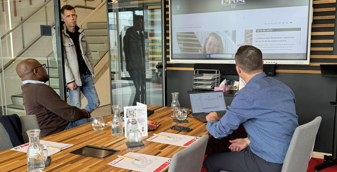 Philippe Lawson en réunion avec Nicolas et Sacha dans les bureaux de e-net, avec un écran affichant le site de l-post.